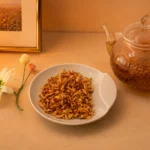 Bitterorangenblütentee aus Iran - Blüten der Bitterorange auf Schale mit Dekoration und Teekanne